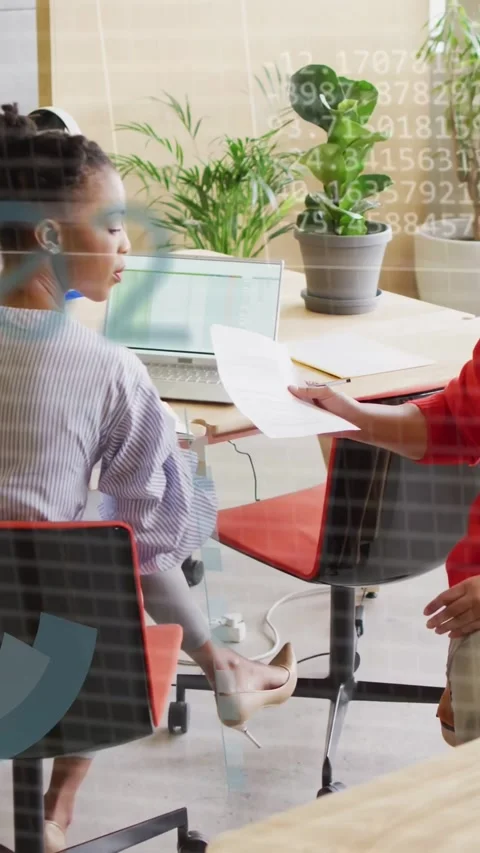 Vertical video: Analyst taking doc from peer, charts showing on pane as checking Stock Footage 333528188
