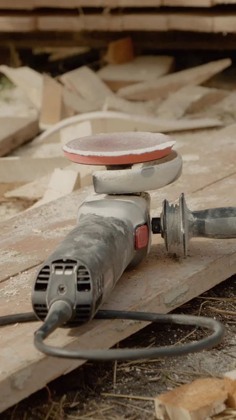Vertical video Angle grinder resting on wooden beams after completing wood Stock Footage 327600851