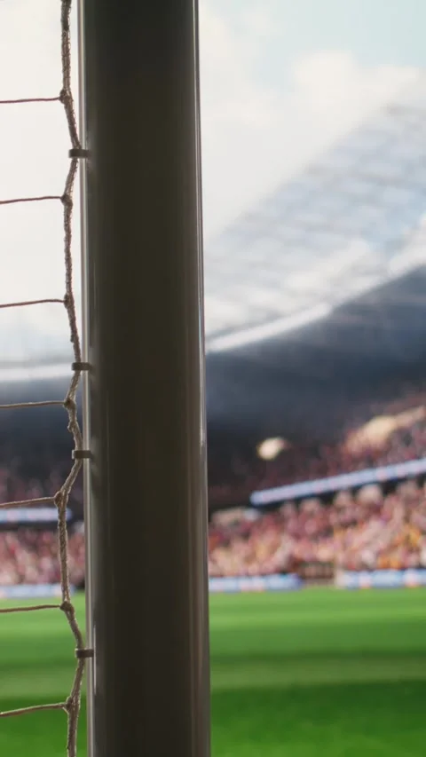 Vertical Video Angled soccer goal net and side post framing empty pitch with Stock Footage 338046653