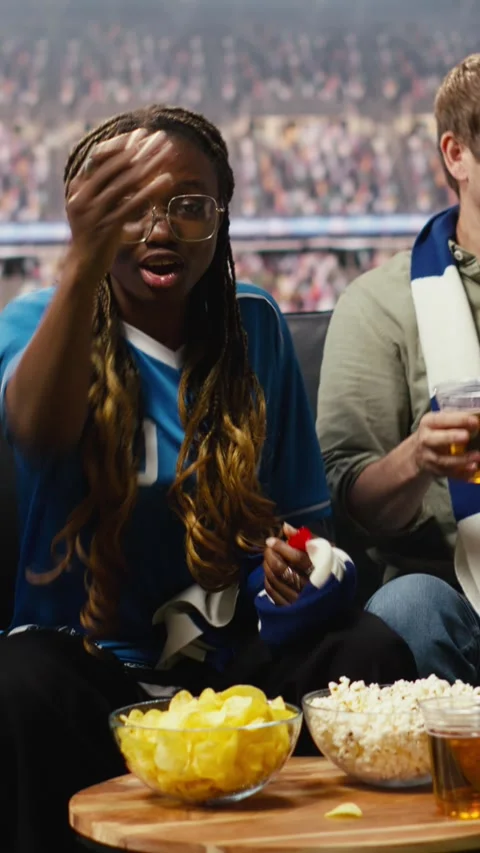Vertical video Anxious supporters with beer watch match broadcast at home Video stock 338186664
