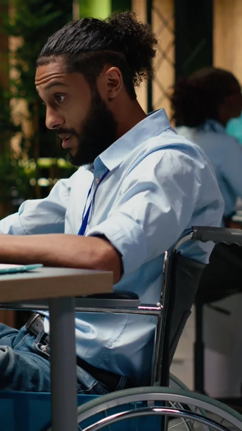 Vertical Video Arab wheelchair user engaged in strategic thinking during late Stock Footage 334105602