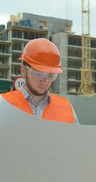 Vertical video. Architect analyzing project plan on construction site. Stock Photos