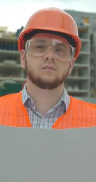 Vertical video. Architect analyzing project plan on construction site. Stock Photos