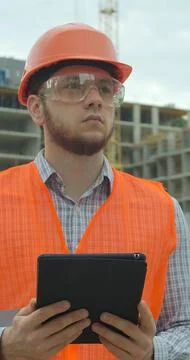 Vertical video. Architect analyzing project plan on construction site with to Stock Photos