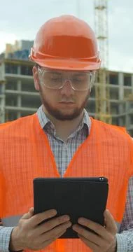 Vertical video. Architect analyzing project plan on construction site with to Stock Photos
