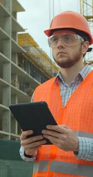 Vertical video. Architect analyzing project plan on construction site with to Stock Photos