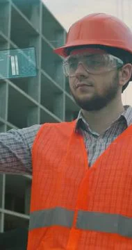 Vertical video. Architect or Engineer using smartphone transparent hologram d Stock Photos