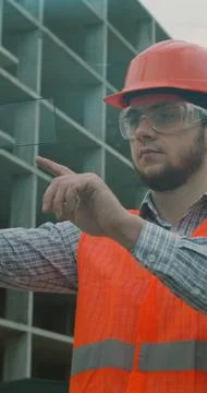 Vertical video. Architect or Engineer using smartphone transparent hologram d Stock Photos