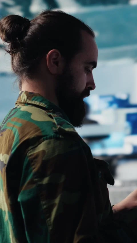 Vertical Video Armed forces officer monitoring drone and satellite imagery for Stock Footage 310702874