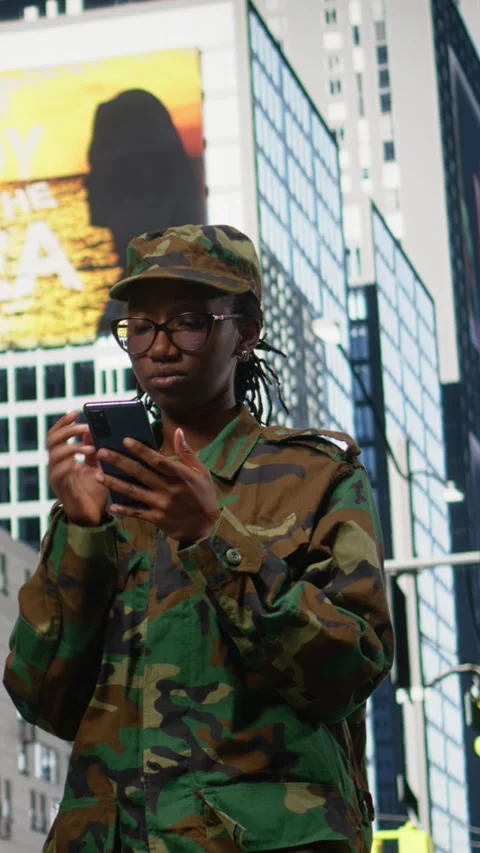 Vertical Video Army soldier examines smartphone map app and walking on city Stock Footage 334200873