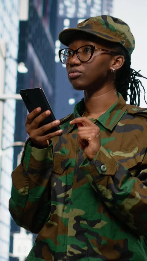 Vertical Video Army soldier examines smartphone map app and walking on city Stock Footage 334203336