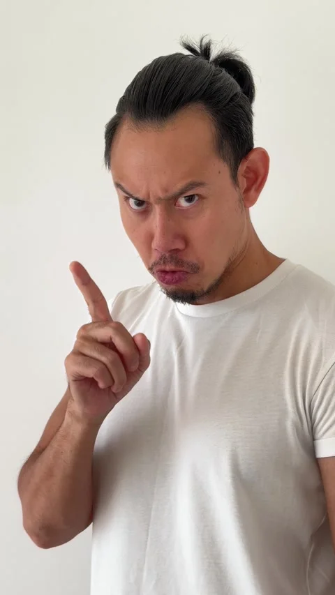 Vertical video of Asian man point at camera with the face of know the secret. Stock Footage 296756986