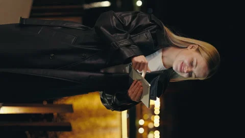 Vertical Video. Attractive Lady Standing in the Night City Using, Scrolling Stock Footage 245886341