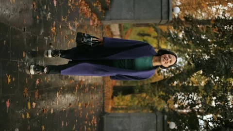 Vertical video, an attractive middle-aged business woman in a long coat Stock Footage 254151558
