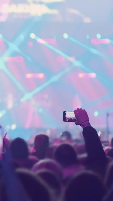 Vertical video: Audience crowd on bright stage lights backdrop at music festival Stock Footage 295304233