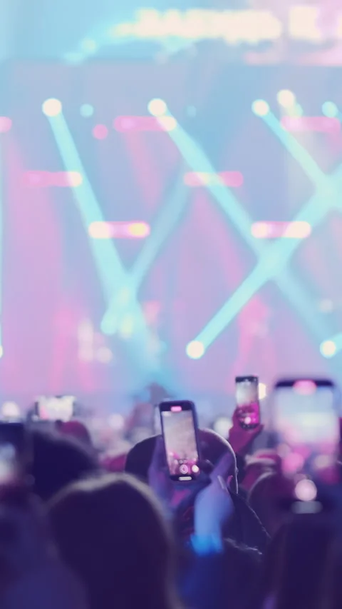 Vertical video: Audience crowd on bright stage lights backdrop at music festival Stock Footage 295304237