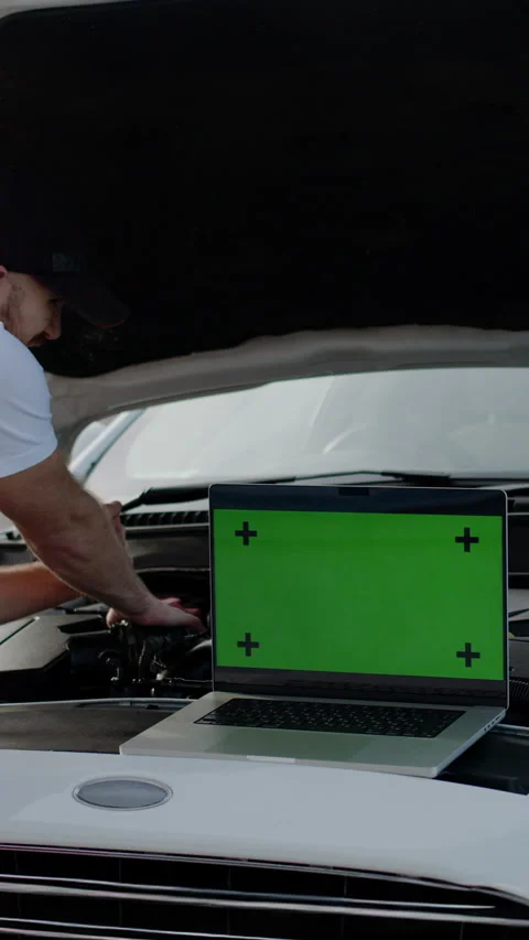 Vertical video. Auto mechanic repairs a car with the help of a computer that Stock Footage 280029797