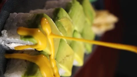 Vertical video avocado rolls are poured with yellow sauce Stock Footage 176390682