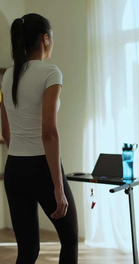 Vertical video. Back view Female is doing cardio workout training on treadmill Stock Footage 336656732
