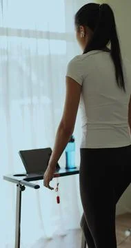 Vertical video. Back view Female is doing cardio workout training on treadm.. Stock Photos