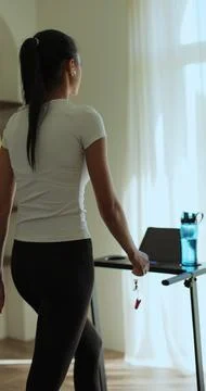 Vertical video. Back view Female is doing cardio workout training on treadm.. Stock Photos