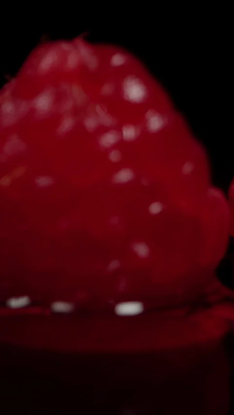 Vertical video. Backing away as raspberry berries fall onto the table with water Stock Footage 270425834
