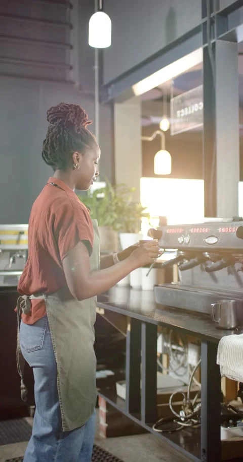 Vertical video: Barista is engaging brew at counter, pulling espresso into cup, Stock Footage 345218163