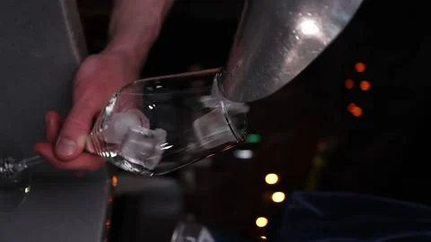 Vertical video the bartender pours ice into a glass slow motion bar Stock Footage 176390585