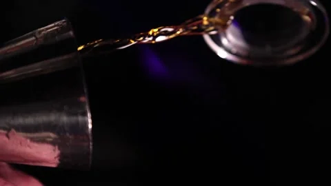 Vertical video the bartender pours whiskey into a jigger Stock Footage 176391074