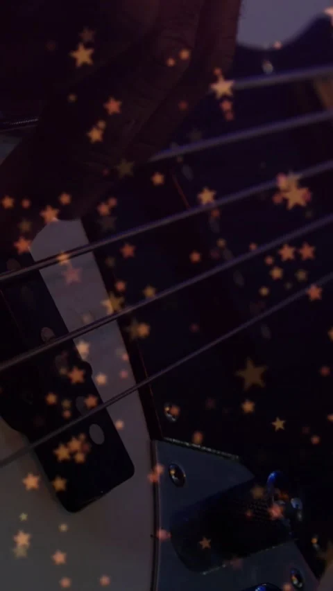 Vertical video: Bass player pressing and plucking strings by pickup, stars Stock Footage 328398189