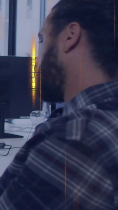 Vertical video: Bearded man sitting desk glancing screen and causing gold Stock Footage 330965946