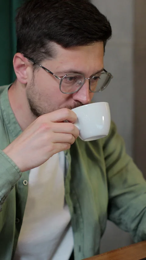 Vertical video. Bearded man working remotely in a cafe using computer devices. Stock Footage 345234958