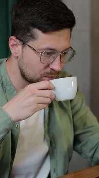 Vertical video. Bearded man working remotely in a cafe using computer devices Stock Photos