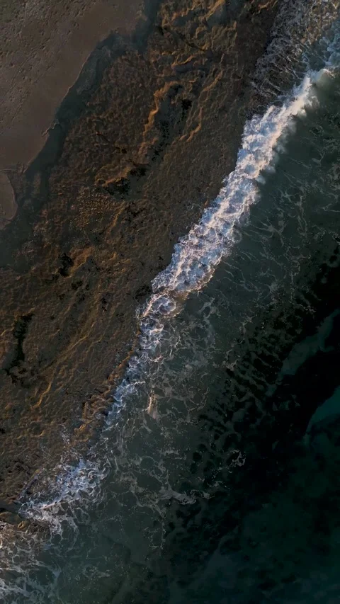 Vertical Video: Beautiful Ocean Texture Illuminated by Sunset Rays Captured in a Stock Footage 342678465