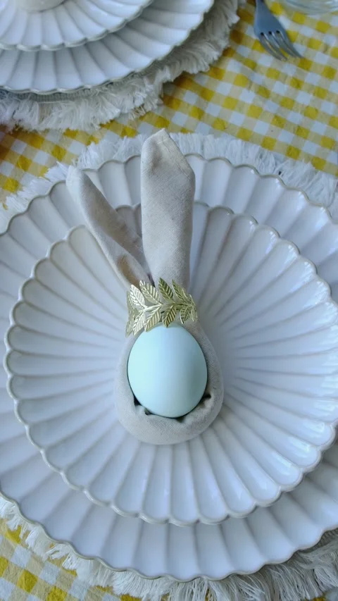 Vertical video. Beautifully set table featuring blue Easter egg on plate 動画素材 332701475