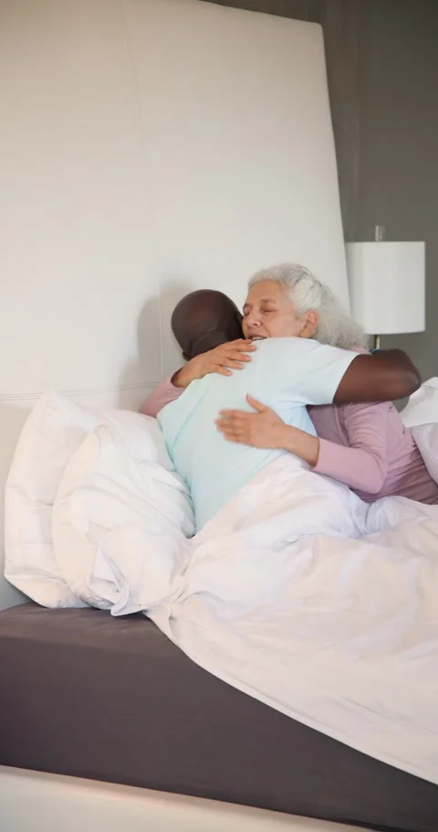 Vertical video: Beeping alarm clock waking senior couple in bed turning off Stock Footage 345217140