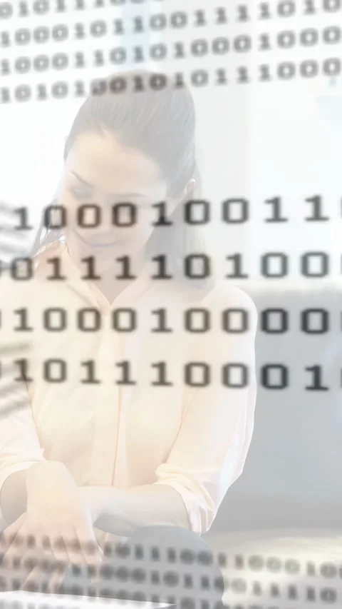 Vertical video: Binary overlay starting focus shift, woman typing, coworker Stock Footage 334544861