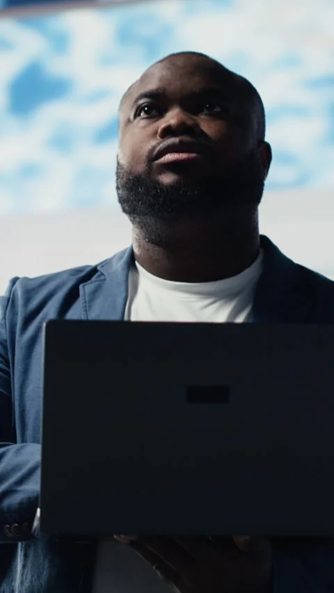 Vertical Video Black coder focused on programming with laptop in a high tech Stock Footage 312177832