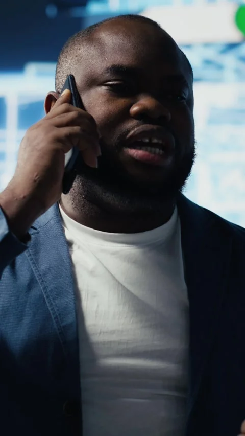 Vertical Video Black entrepreneur using mobile phone call to interact with Stock Footage 312123496