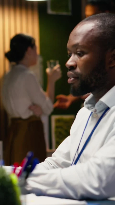 Vertical Video Black man accountant in office using laptop and writing down Stock Footage 334106007