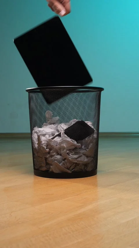 Vertical video black mesh waste basket on a wooden floor, collecting crumpled Stock Footage 342758859