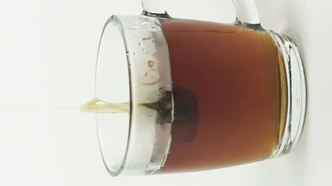 Vertical video black tea bag lifting and dropping into glass transparent mug to Stock Footage 151994893