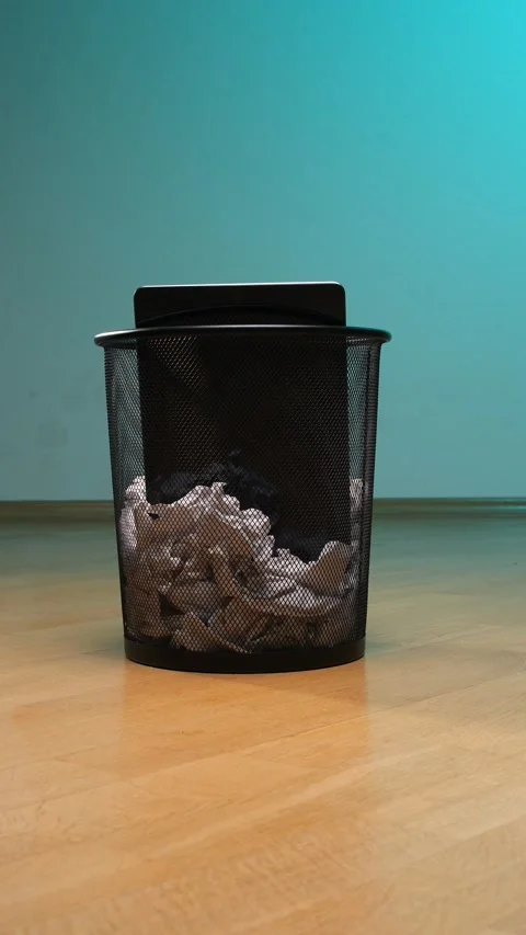 Vertical video black wire mesh trash bin standing on a wooden floor, partially Stock Footage 342758839