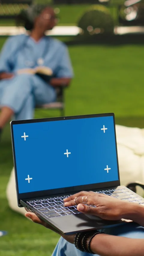 Vertical Video Blue screen chroma key on laptop held by black medical student Stock Footage 341321160
