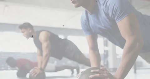 Vertical video: Blue-shirt man and partners doing medball push-ups for fitness, Video stock 331002268