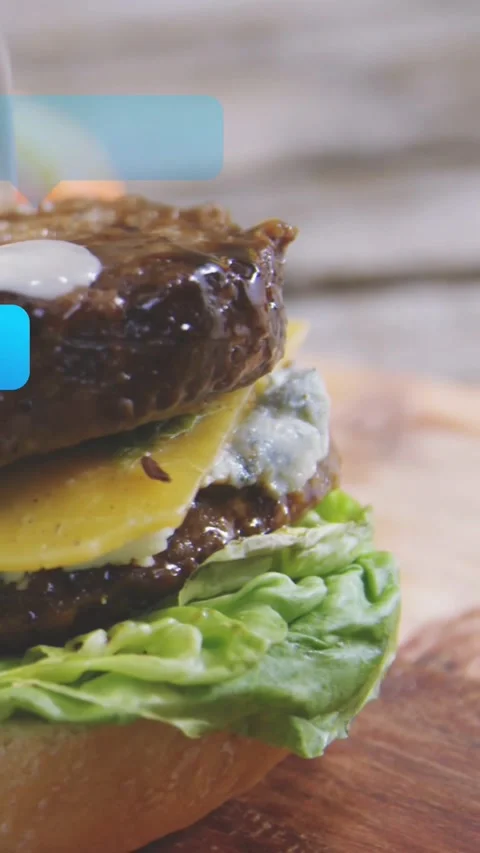 Vertical video: Blue tag sliding in over burger causing sauce to pour moving Stock Footage 328398479