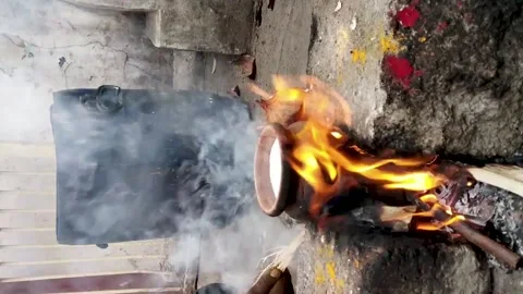 Vertical video of boiling of milk in a earthen urn using firewood on a tradit Stock Footage 134253334
