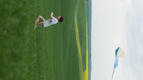 Vertical video. The boy launched a kite and ran with him across the field. Video stock 214468589