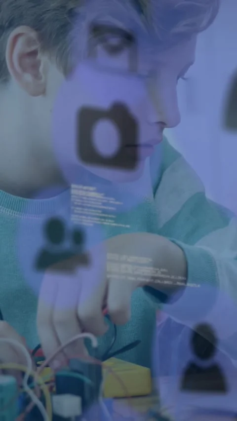 Vertical video: Boy looking and tuning wires in STEM lab purple overlay icons Stock Footage 329840462