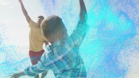 Vertical video: Boy playing raising arms on shore making blue tech wave, dad Stock Footage 332505329